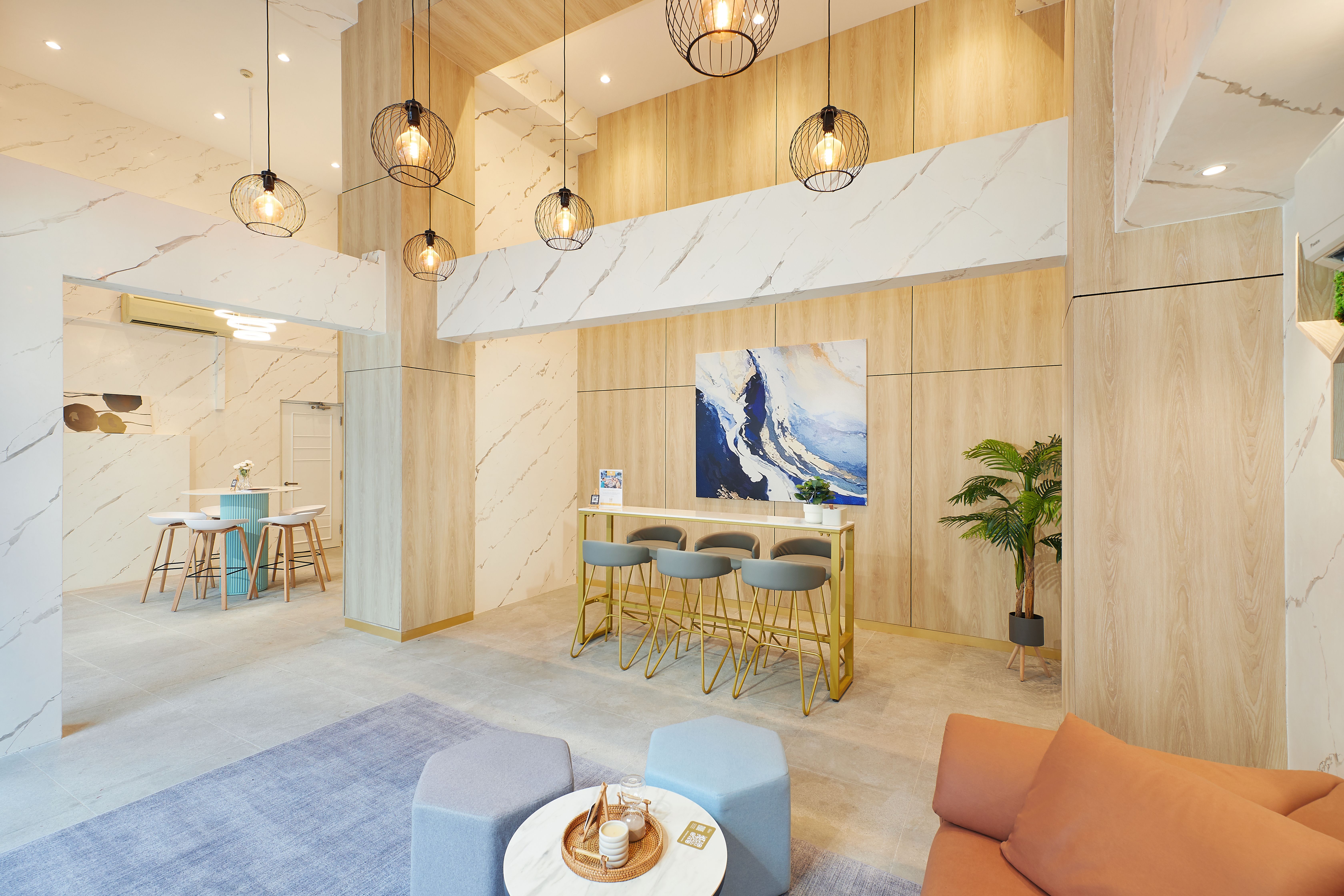 Modern minimalist reception area with a gold bar, abstract art, and contemporary lighting.