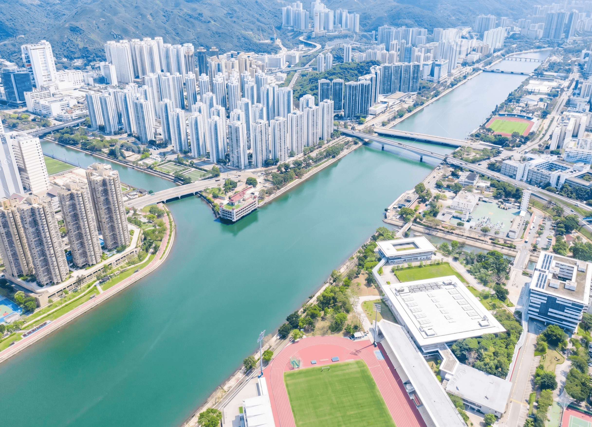 Aerial view of a modern city with tall buildings along a wide river.