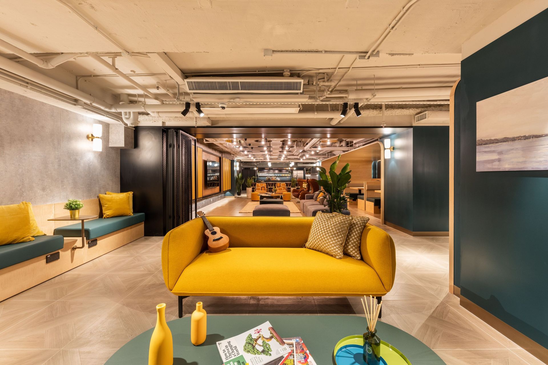 Modern lounge area with a vibrant yellow sofa, built-in seating, and a reflective background.